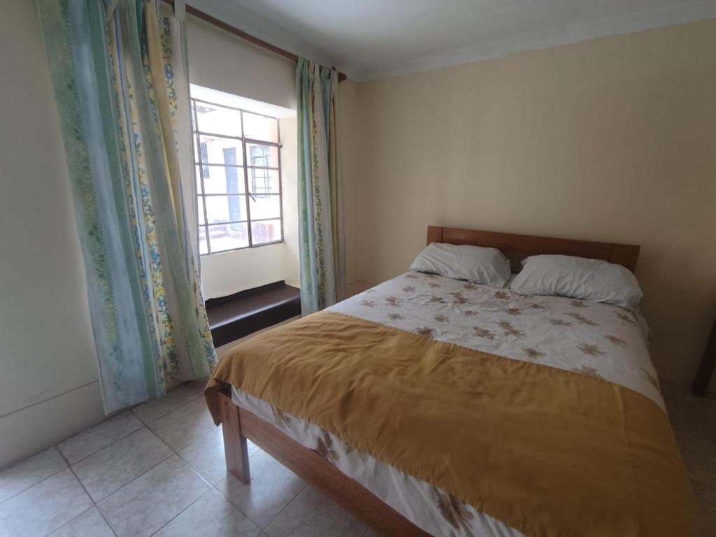 a bedroom with a bed and a window at la casa de la guajira in Cusco