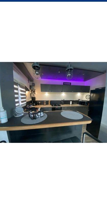 Cette grande chambre dispose d'une table et d'un éclairage violet. dans l'établissement La maison d hôte d emmanuelle, à Saint-Antoine-la-Forêt