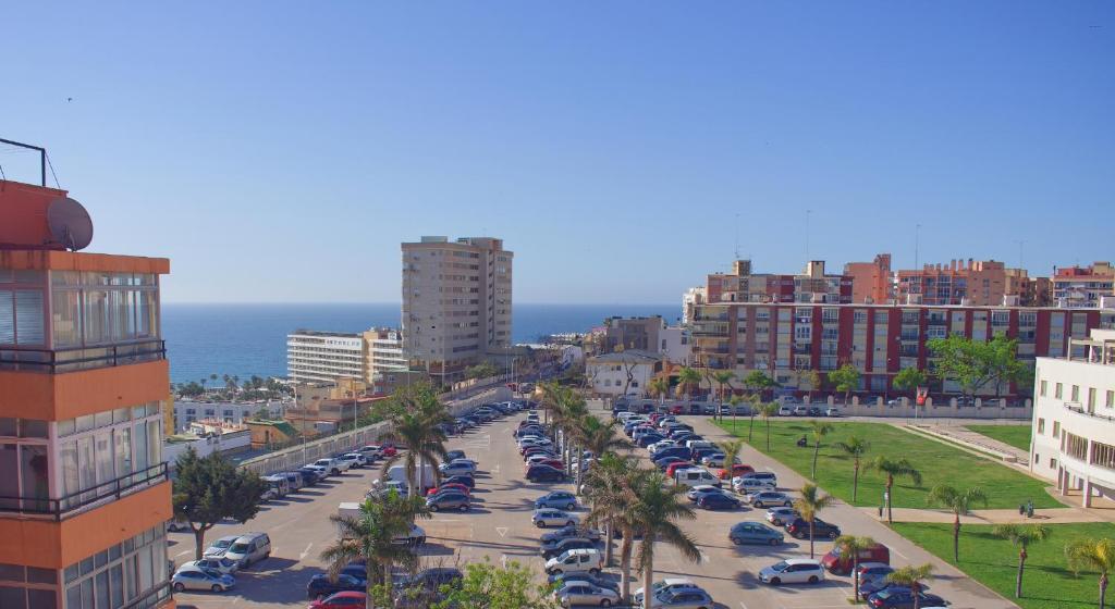 a city street with cars parked in a parking lot at Costa del Sol Apartment in Torremolinos