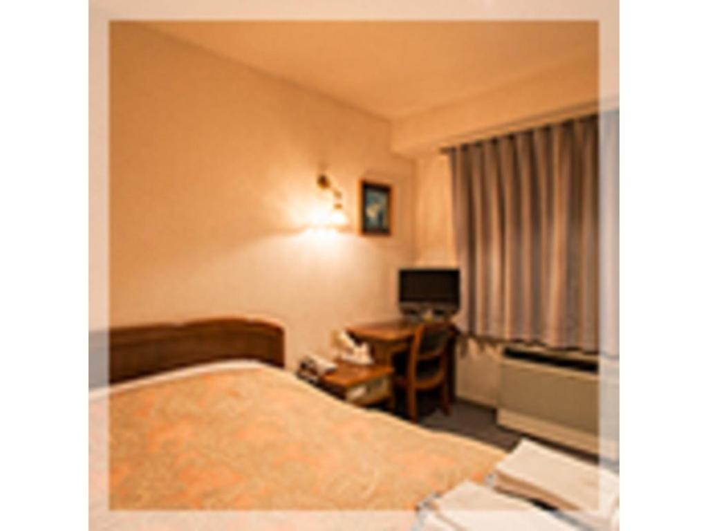 una camera d'albergo con letto e scrivania di Famy Inn Makuhari - Vacation STAY 16040v a Chiba