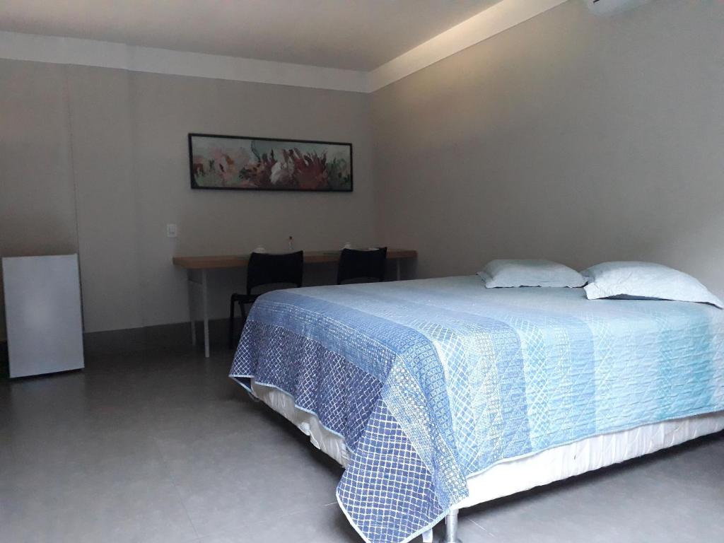 sypialnia z łóżkiem i stołem z krzesłami w obiekcie STUDIO CENTRAL IV w mieście Cascavel