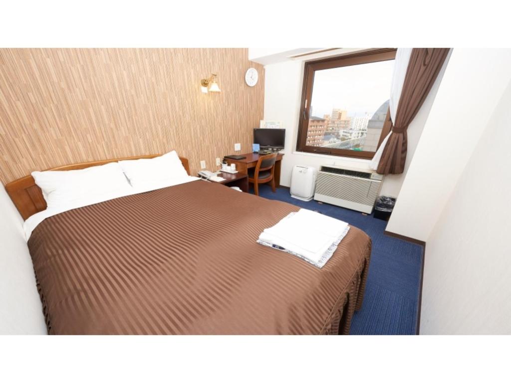 a hotel room with a bed and a window at Famy Inn Makuhari - Vacation STAY 16038v in Chiba