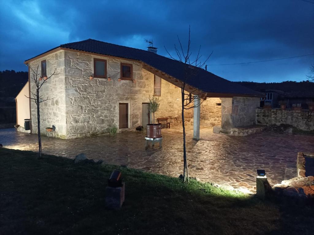 a stone house with a courtyard in front of it at Albergue Aldea da Pedreira in Teo