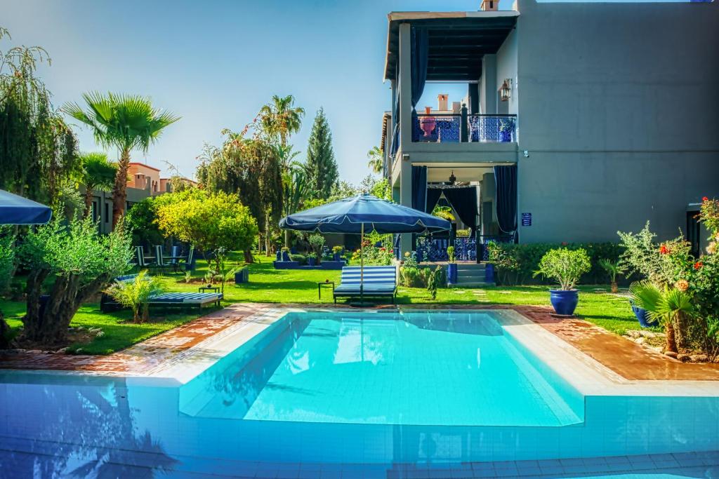 a swimming pool in front of a house at Villas 95 Appart'Hôtel in Marrakech