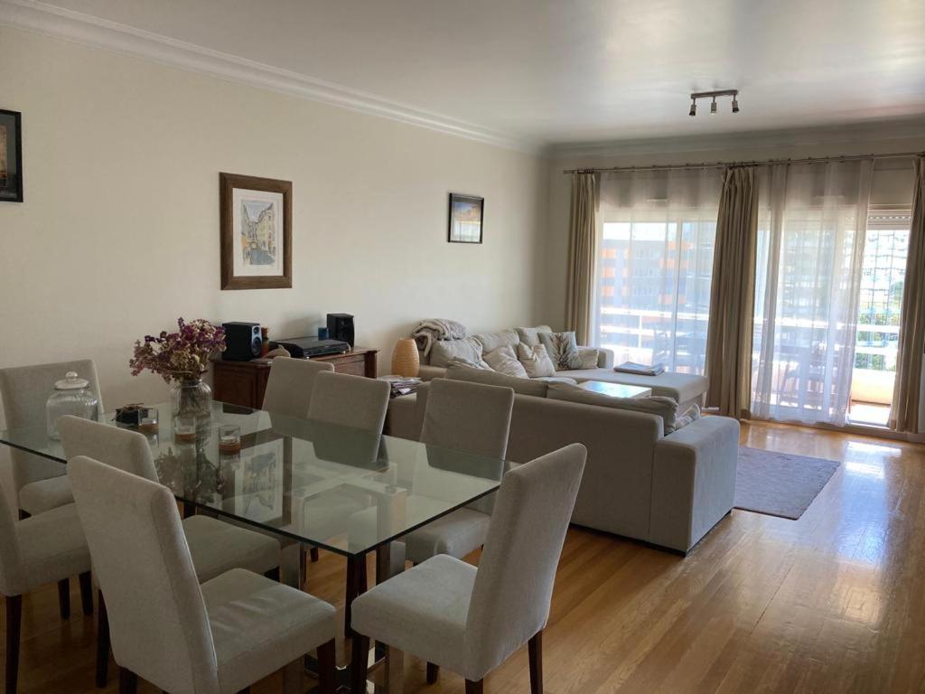 a living room with a glass table and a couch at Lisbonne in Algés