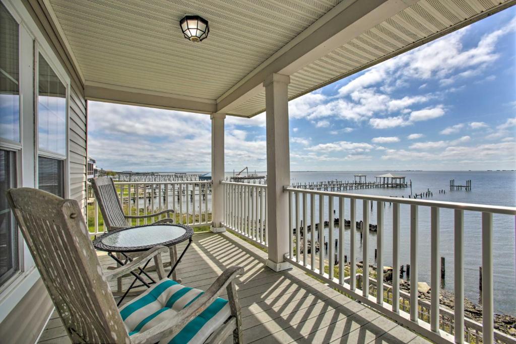 een veranda met een tafel en stoelen en de oceaan bij Waterfront New Orleans Home with Private Dock and Pier in Venetian Isles