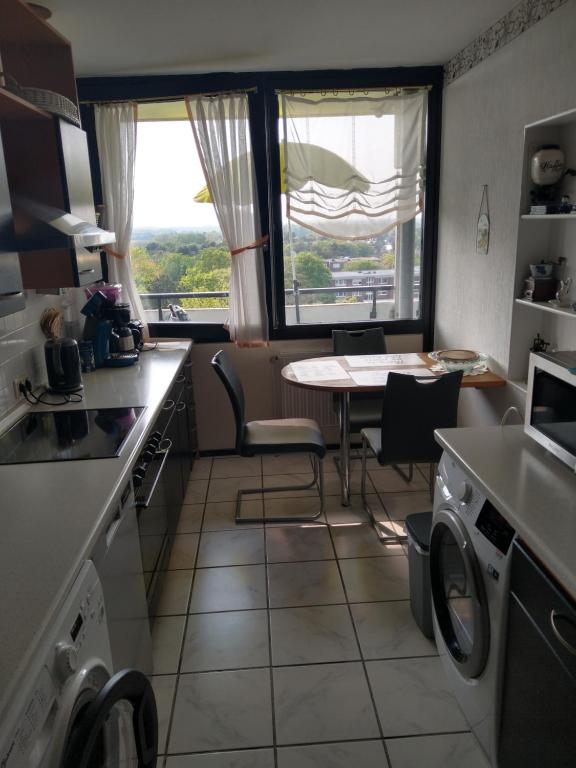 een keuken met een tafel en stoelen en een raam bij Veronika in Erftstadt