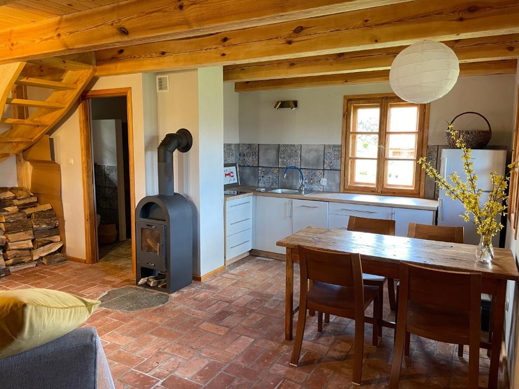 a kitchen with a table and a wood stove at Domy w Lipowie - dom żółty in Piecki