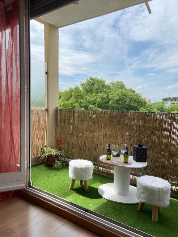 d'une terrasse avec une table, deux chaises et une fenêtre. dans l'établissement Appartement Circé - Montpellier Nord-Hopitaux-Facultés, à Montpellier