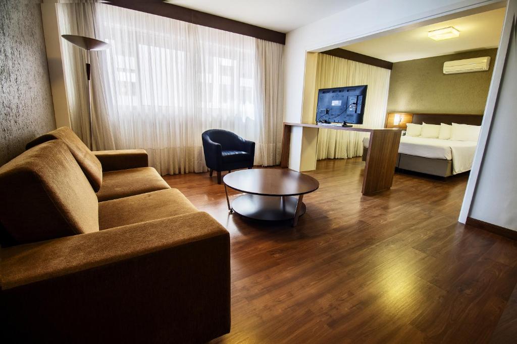 a living room with a couch and a table at Hotel Deville Curitiba Batel in Curitiba