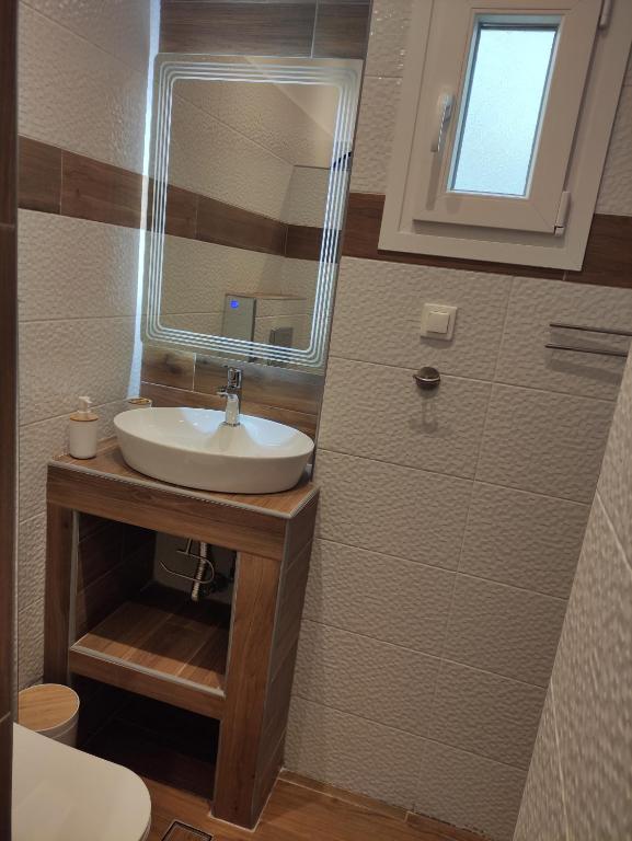 a bathroom with a sink and a mirror at Poseidon Rooms in Kala Nera