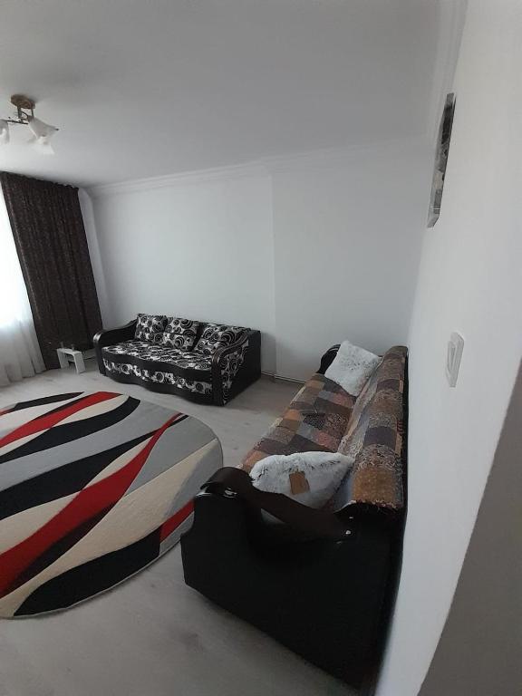 um quarto com duas camas e um sofá em Apartament La Denis em Bîrlad
