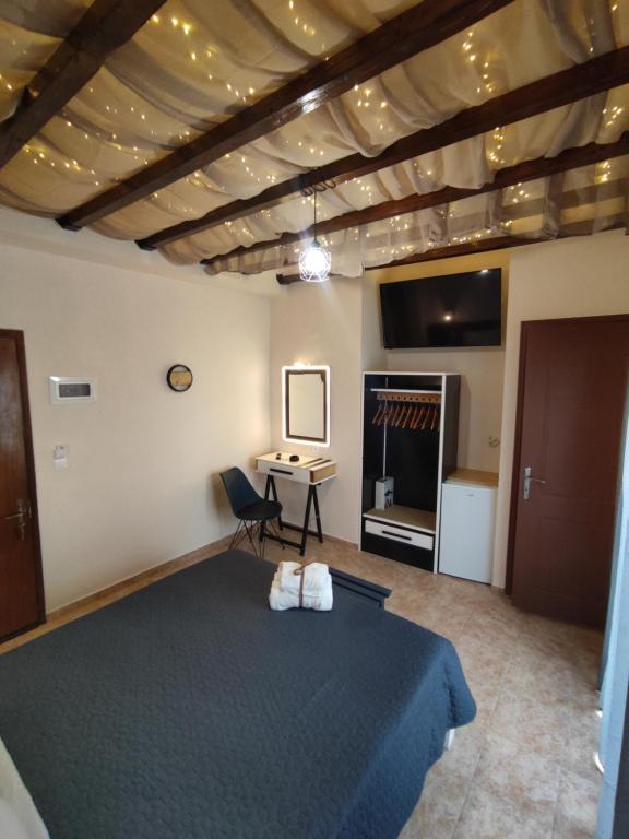 a bedroom with a large bed and a desk at Poseidon Rooms in Kala Nera