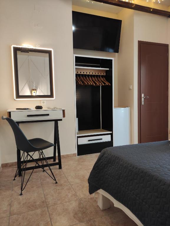 a bedroom with a desk and a bed and a mirror at Poseidon Rooms in Kala Nera
