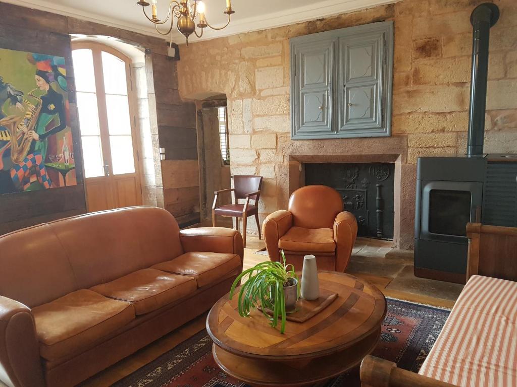 ein Wohnzimmer mit einem Sofa und einem Tisch in der Unterkunft Demeure pittoresque en pierres 1741 - 3 étoiles - 12 personnes in Arpenans