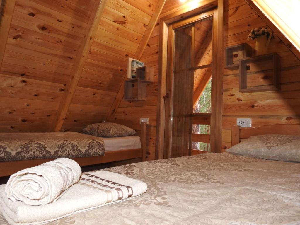 Un dormitorio con dos camas en una cabaña de madera. en The Pine Forest Cottage, en Žabljak