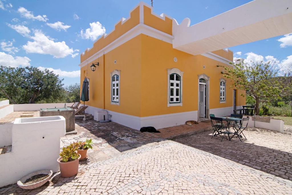 聖巴巴拉德尼克斯的住宿－Algarve Charming 2br Colonial Villa，一座带庭院的黄色小房子