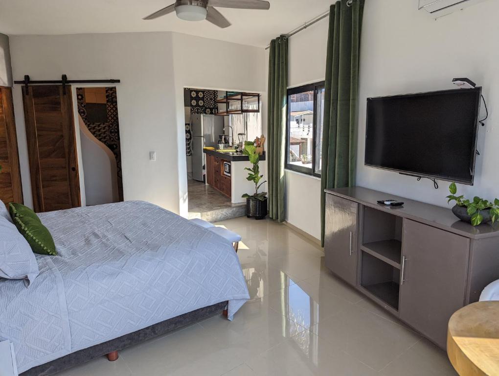 a bedroom with a bed and a flat screen tv at Hotel Pura Chacala in Chacala