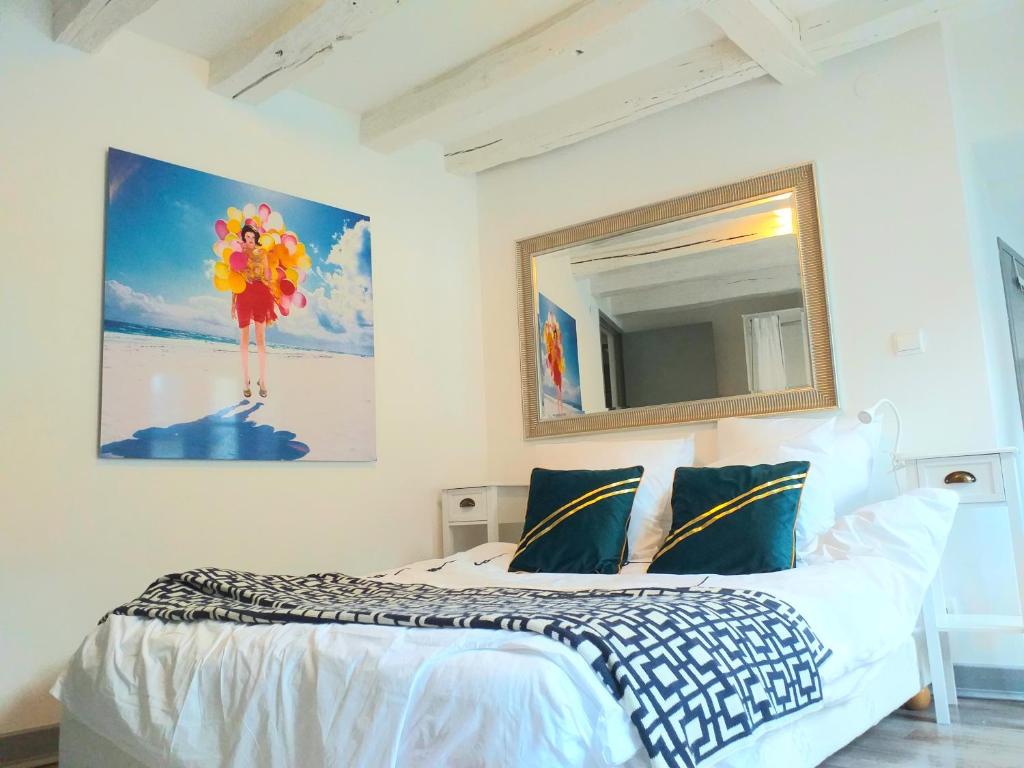 a bedroom with a bed with a painting on the wall at A la Grosse Armée - Dans hôtel particulier, hypercentre avec garage, au calme in Bourges