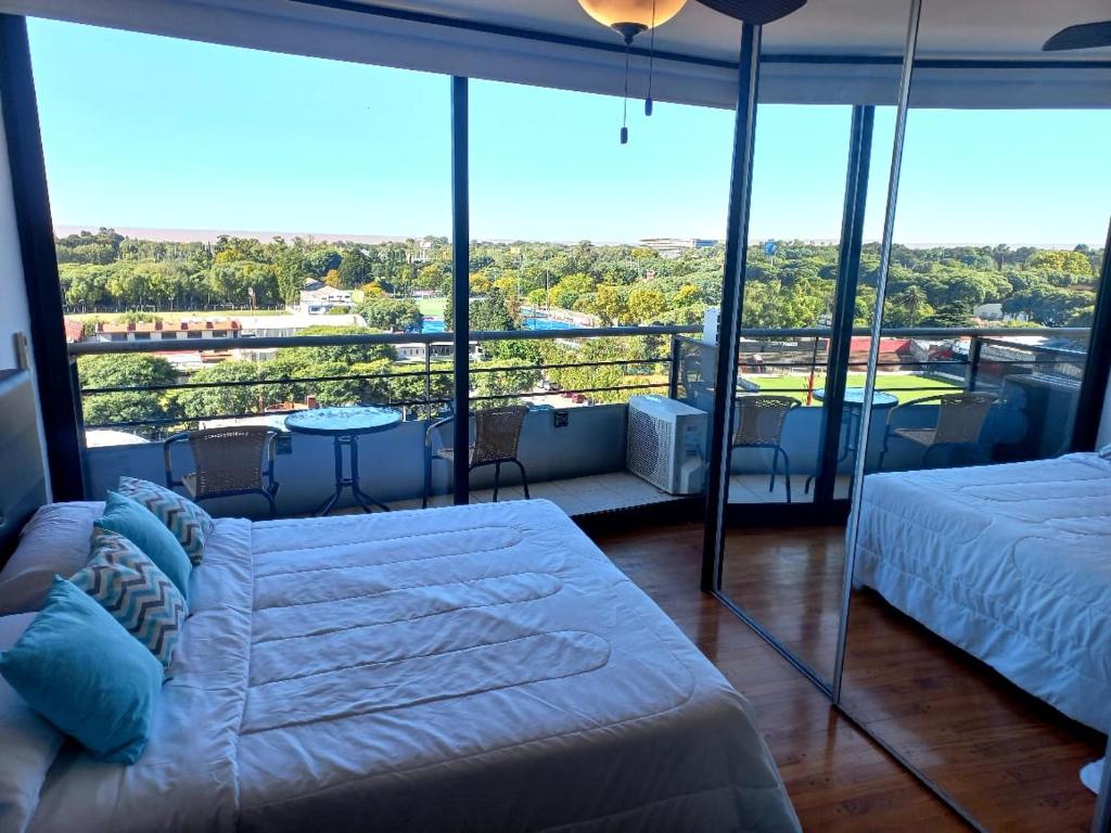 1 dormitorio con 1 cama y balcón con vistas. en Departamento temporario en nuñez libertador con vista al río!! en Buenos Aires