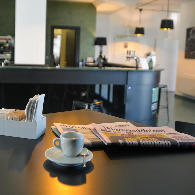 a table with a cup of coffee and a napkin at Tuo Hotel in Polignano a Mare