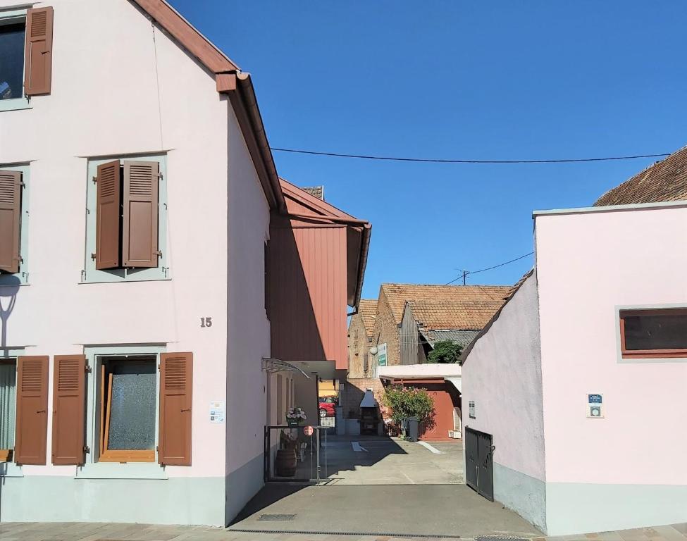 un callejón en una ciudad con edificios blancos en Location-Meublé en Issenheim