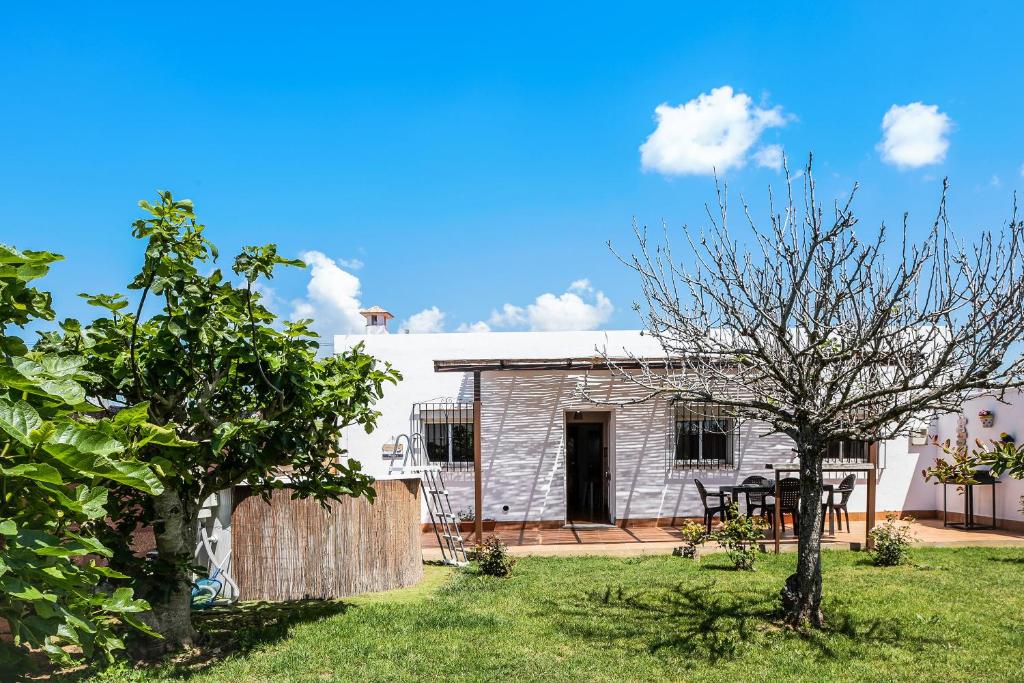a white house with a yard with a table at Villa Zajara in Conil de la Frontera