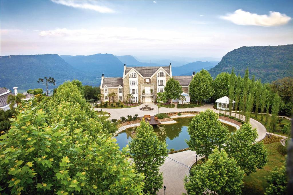 uma vista aérea de uma grande casa com um lago em Castelo Saint Andrews em Gramado