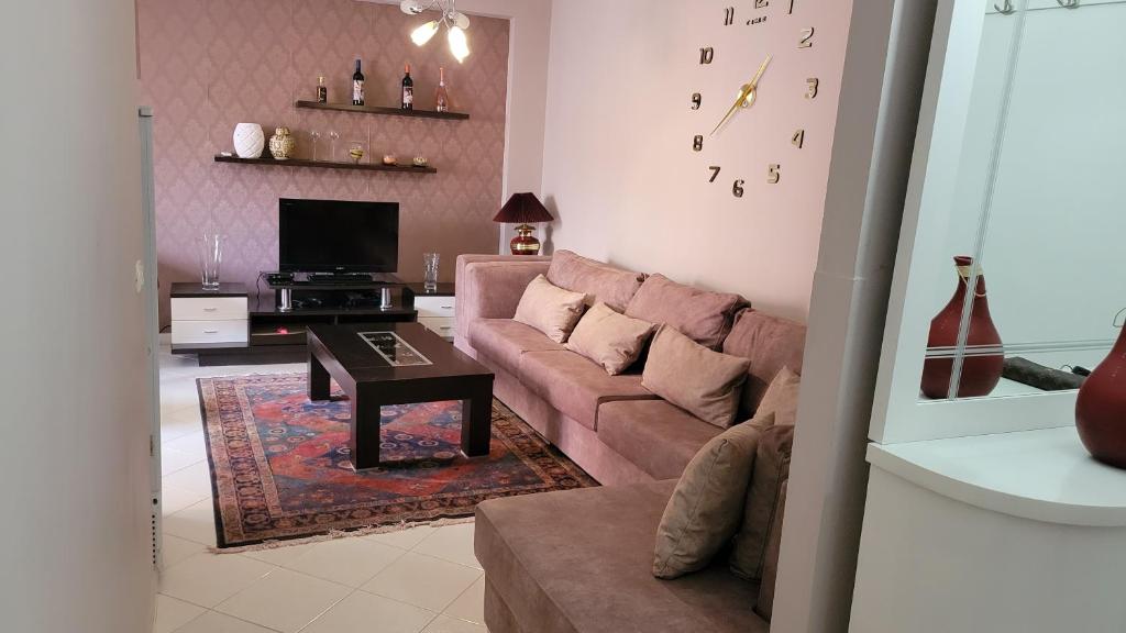 a living room with a couch and a table at Charming Apartment Lushnje in Lushnjë