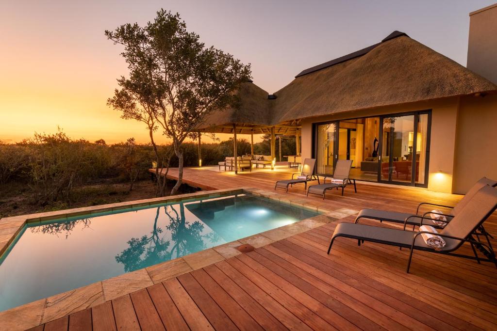 a house with a swimming pool on a wooden deck at Villa Tall Horse - solar powered in Hoedspruit