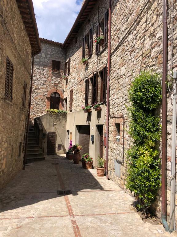 un callejón en un antiguo edificio de piedra con macetas en Casa in Umbria, en Monte Castello di Vibio