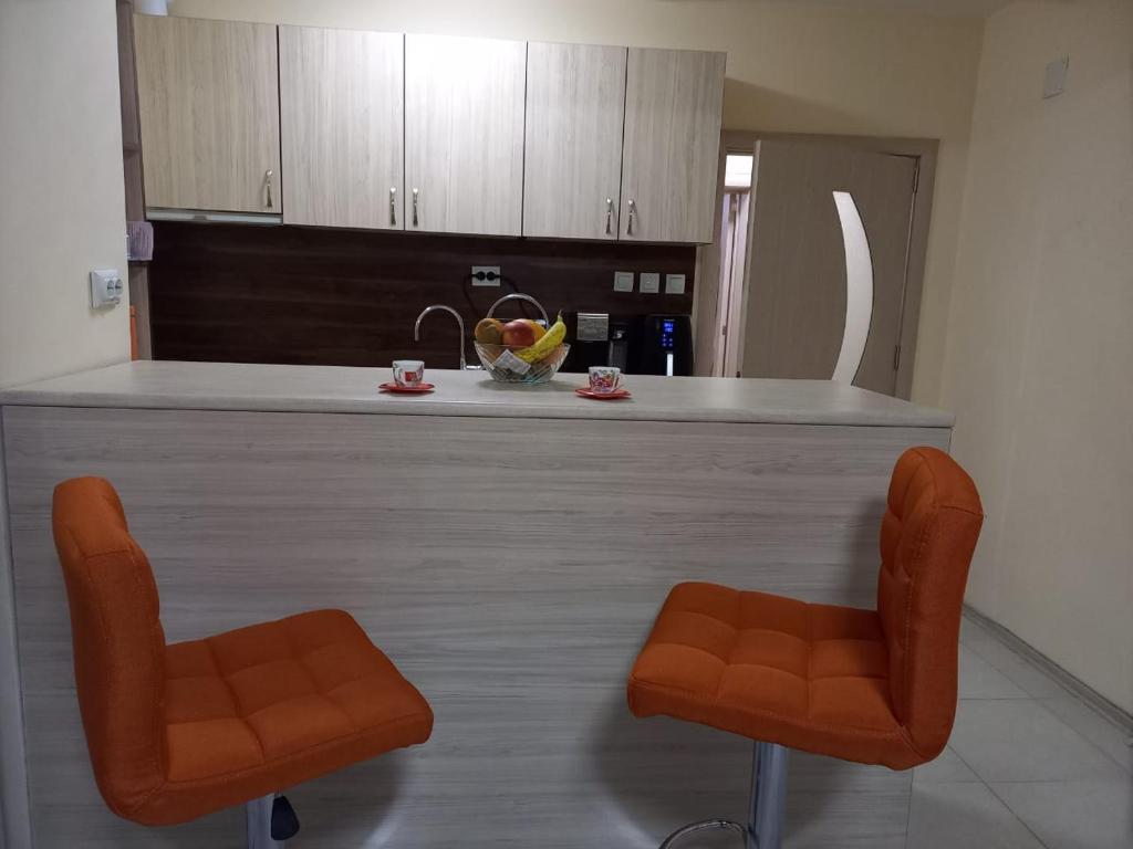 a kitchen with two orange chairs and a counter at Dima's place in Kazanlŭk