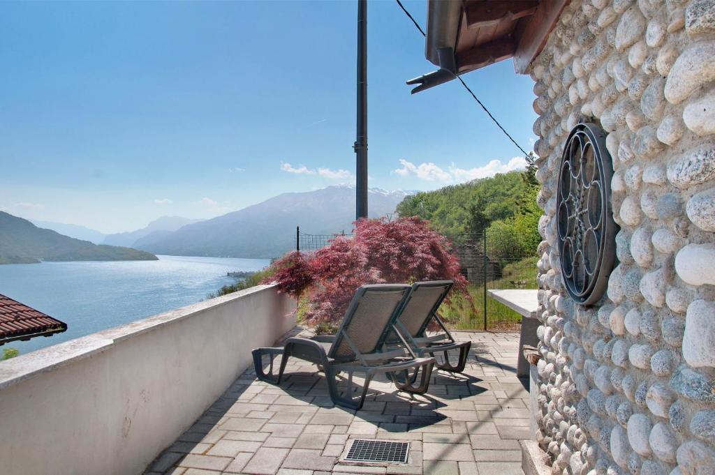 a couple of chairs sitting on a balcony overlooking a lake at Casa Alan in Gera Lario