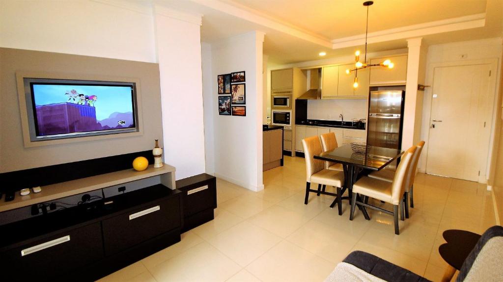 sala de estar y cocina con mesa y TV en 1044 - Apartamento de 01 dormitório em Bombinhas - Residencial Egídio Pinheiro 101 B, en Bombinhas