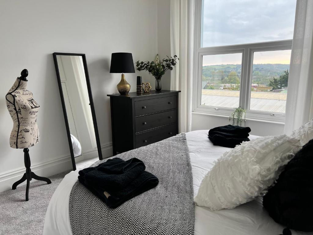 a bedroom with a bed with two black towels on it at Heathcliff - 5 Bedroom House in Town Centre in Pembrokeshire