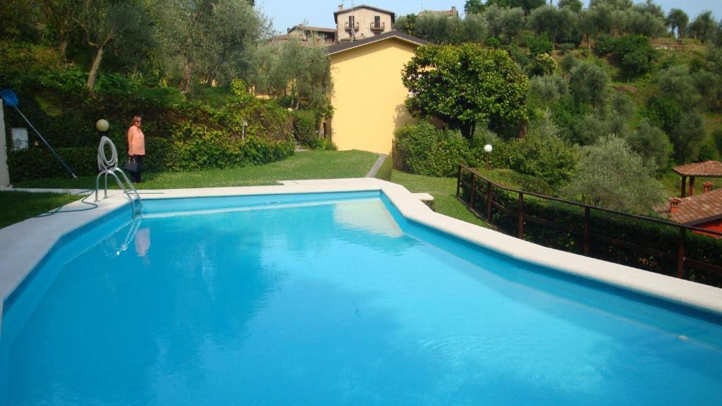 a large blue swimming pool in front of a house at Apartment Fasano Sopra in Gardone Riviera