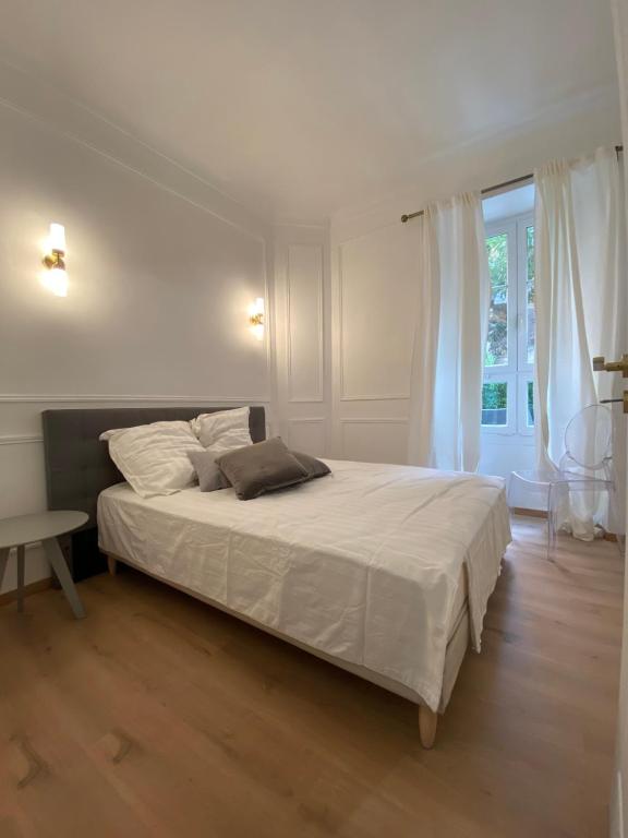 - une chambre avec un grand lit blanc et une fenêtre dans l'établissement Lovely Spacious Large Patio Heart of Monaco, à Beausoleil
