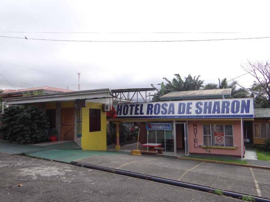Un viejo motel con un cartel que lee Hotel Rosa de Sharon en Hotel Rosa De Sharon, en Marsella