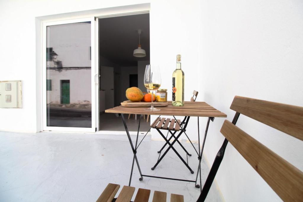 una mesa con una botella de vino y una copa en CASA MAR GINES , COMODIDAD Y CERCANIA A TU MANO. en La Santa