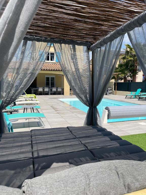 - un lit à baldaquin à côté de la piscine dans l'établissement Maison 8-10 pers avec piscine aux portes de St Aygulf, à Fréjus