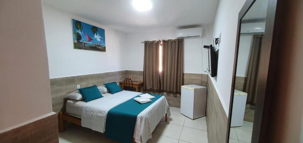 a bedroom with a bed with blue pillows at Pousada Águas Douradas in Aracaju