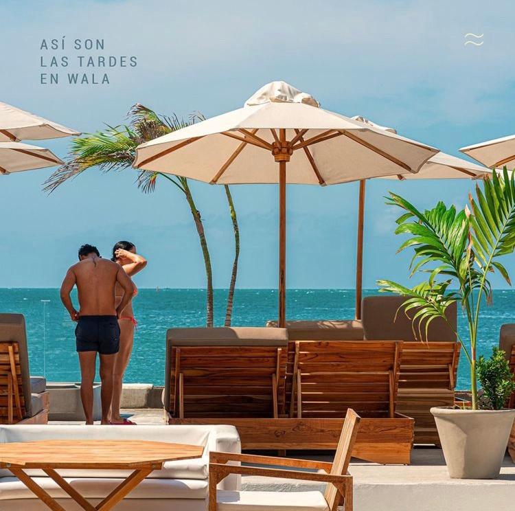 Ein Mann steht am Strand und schaut auf den Ozean in der Unterkunft Wala beach club in Cartagena de Indias