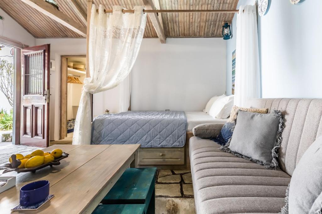 a living room with a couch and a table at Yianna Cottage Studios in Skopelos Town