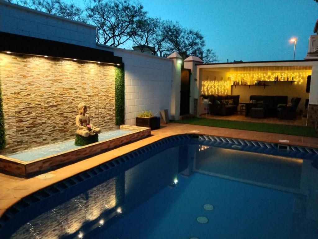 una mujer sentada al lado de una piscina por la noche en Luxury Sunny Villa, en Málaga