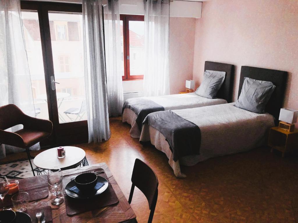 Habitación de hotel con 2 camas y mesa de centro en Paisible studio avec agréable loggia 2 mn du centre, en Aix-les-Bains