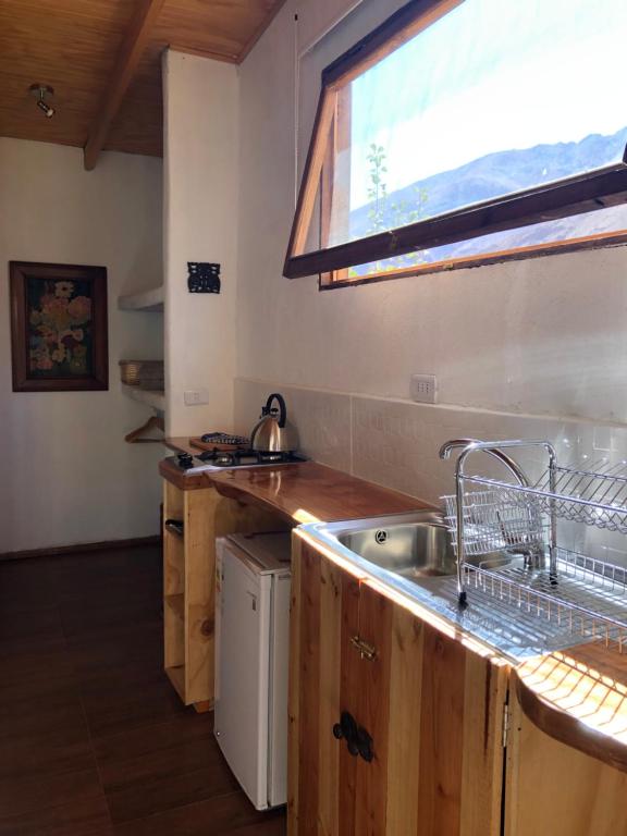 cocina con fregadero y ventana en Cabañas Elquimista, en Pisco Elqui