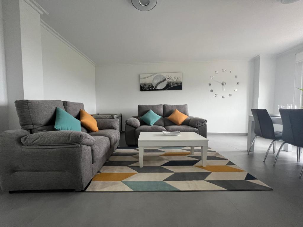 salon z dwiema kanapami i stołem w obiekcie Apartamentos María de Lucía-Piso 2º w mieście Arou