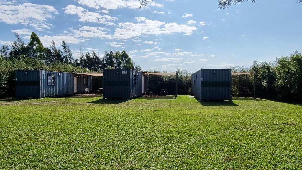 drei tragbare Toiletten auf einem Grasfeld in der Unterkunft Complejo Containers DF in Termas del Daymán