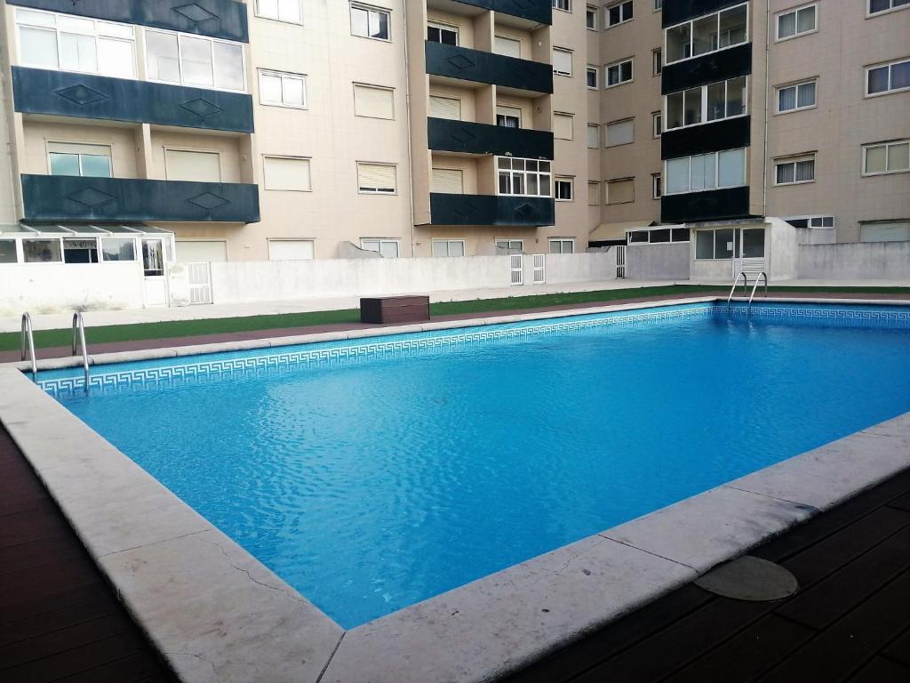 una grande piscina blu di fronte a un edificio di AREAL a Praia da Vagueira