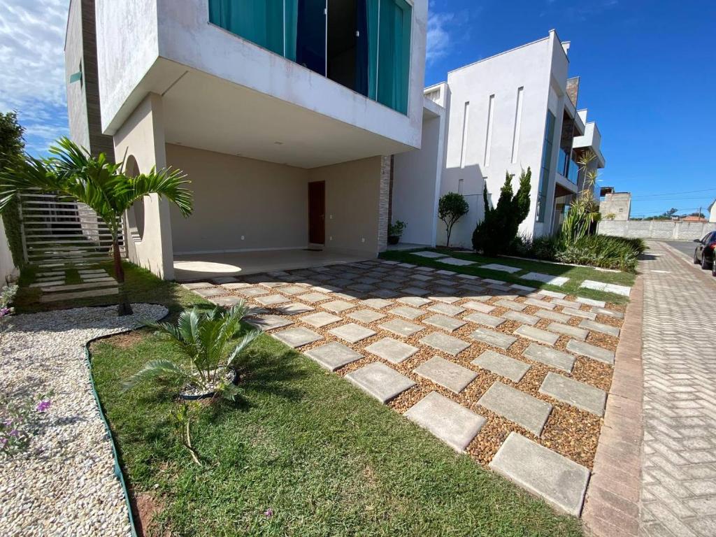 una casa con una pasarela de piedra delante de ella en Duplex em Guarapari com piscina privativa!, en Guarapari